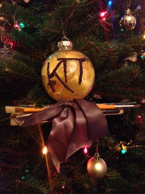 Zeta Omicron Christmas Ornament with a bow and paintbrushes
