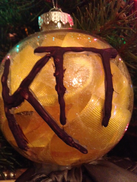 Zeta Omicron Christmas Ornament with a bow and paintbrushes