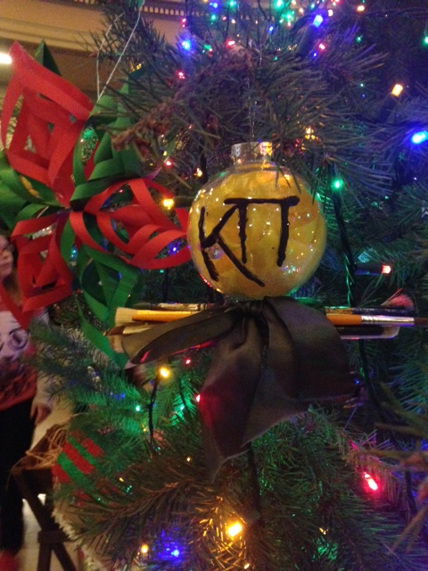 Zeta Omicron Christmas Ornament with a bow and paintbrushes