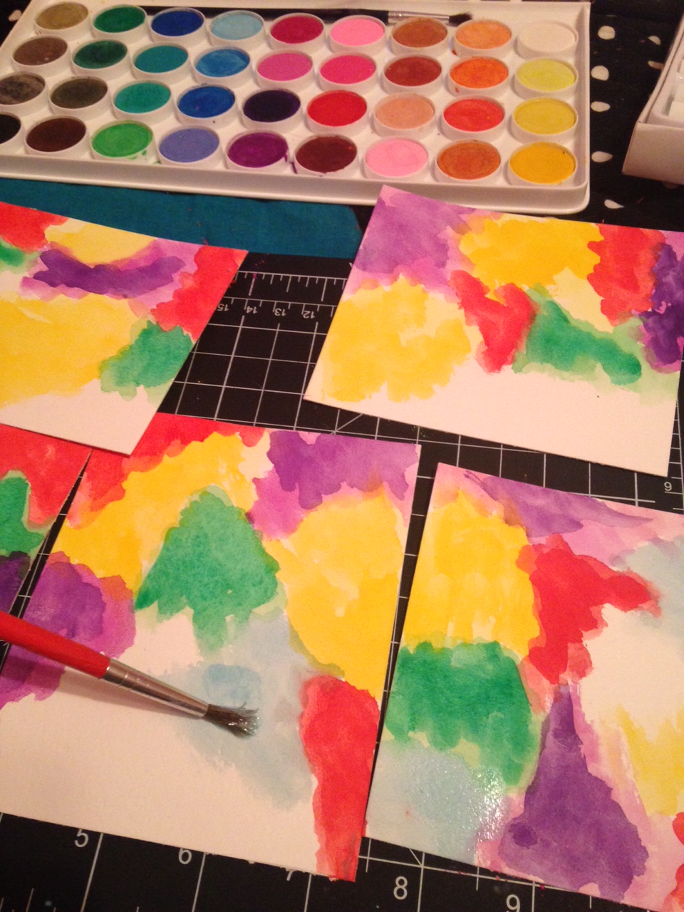 painting with rainbow color water colors filling all five tiny sheets of paper