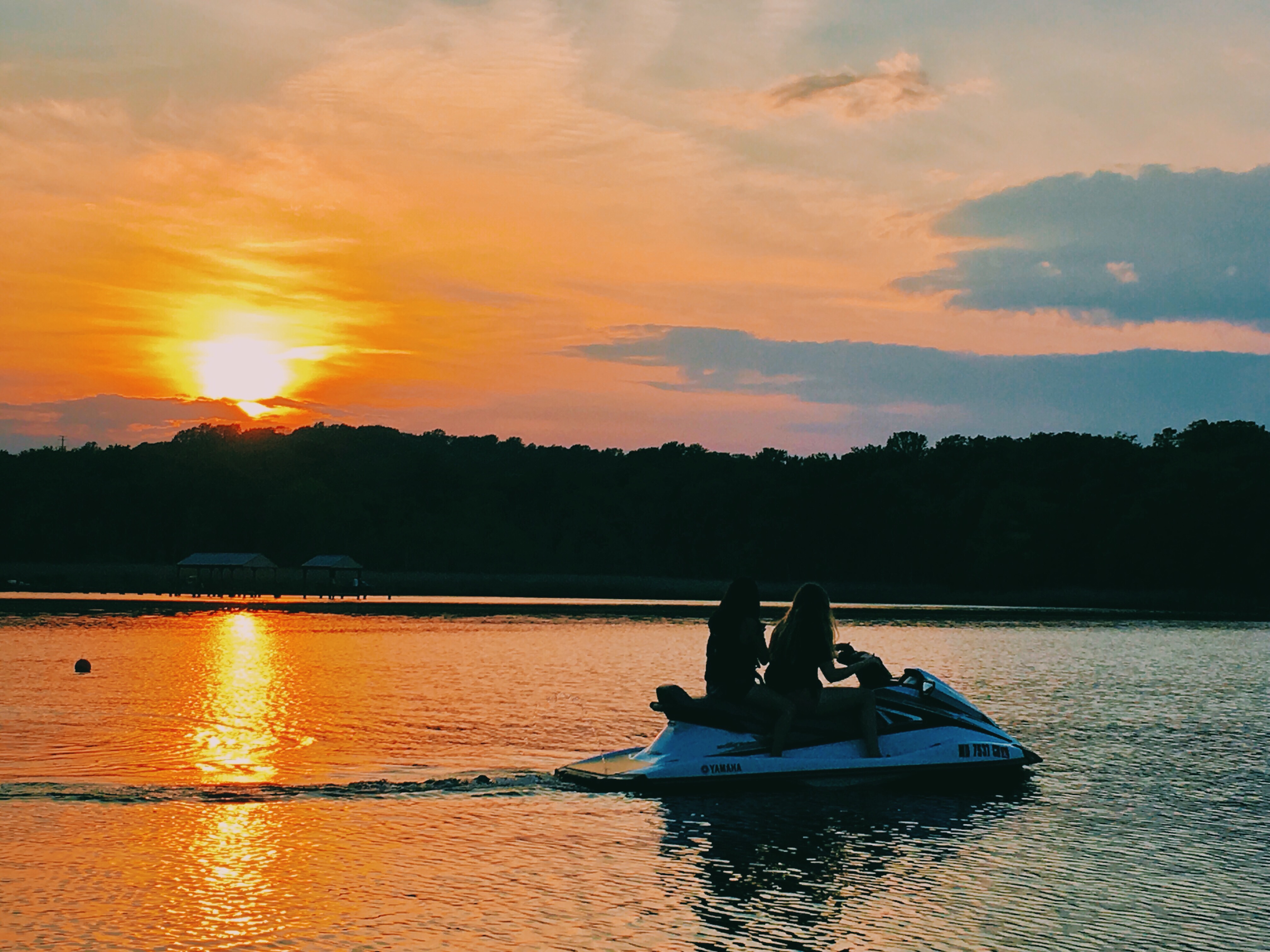 Orange sunset with two girls on a jetski
