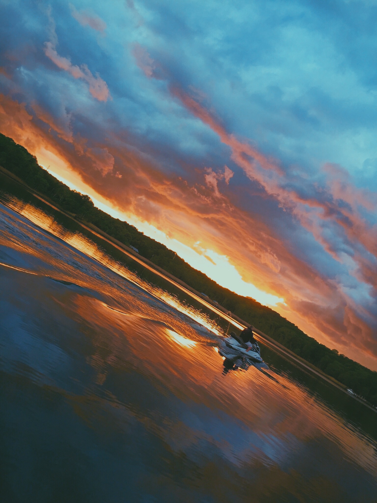 Blue to orange sunset with man on jetski