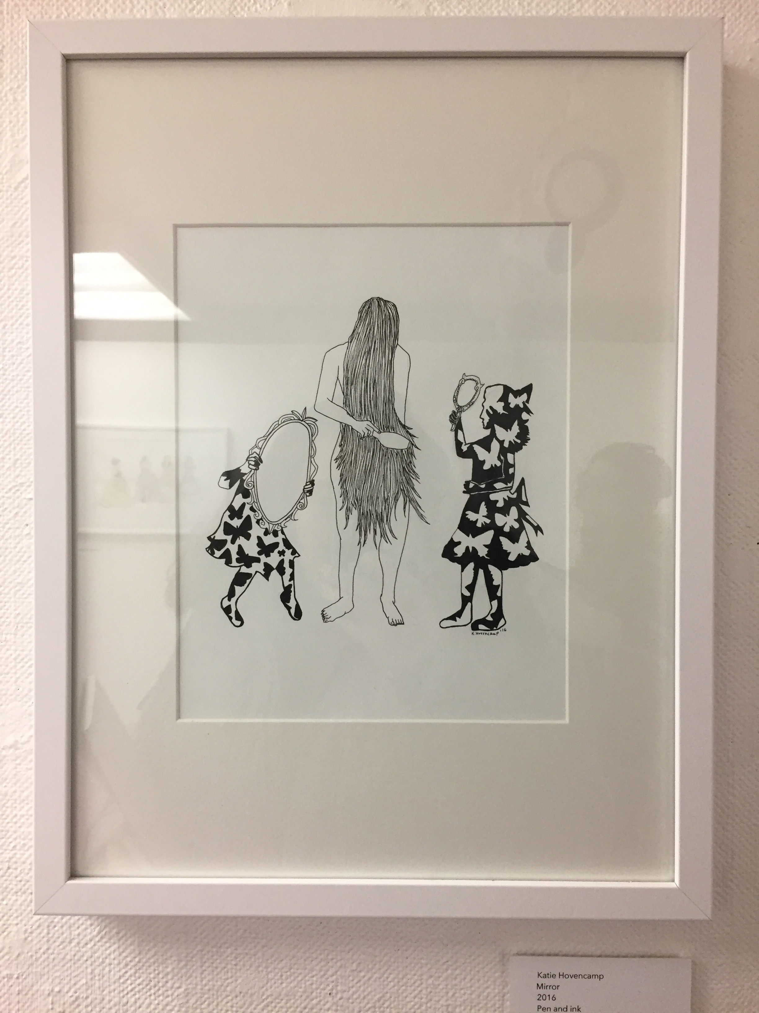 woman brushing her hair with 2 mirrors facing her