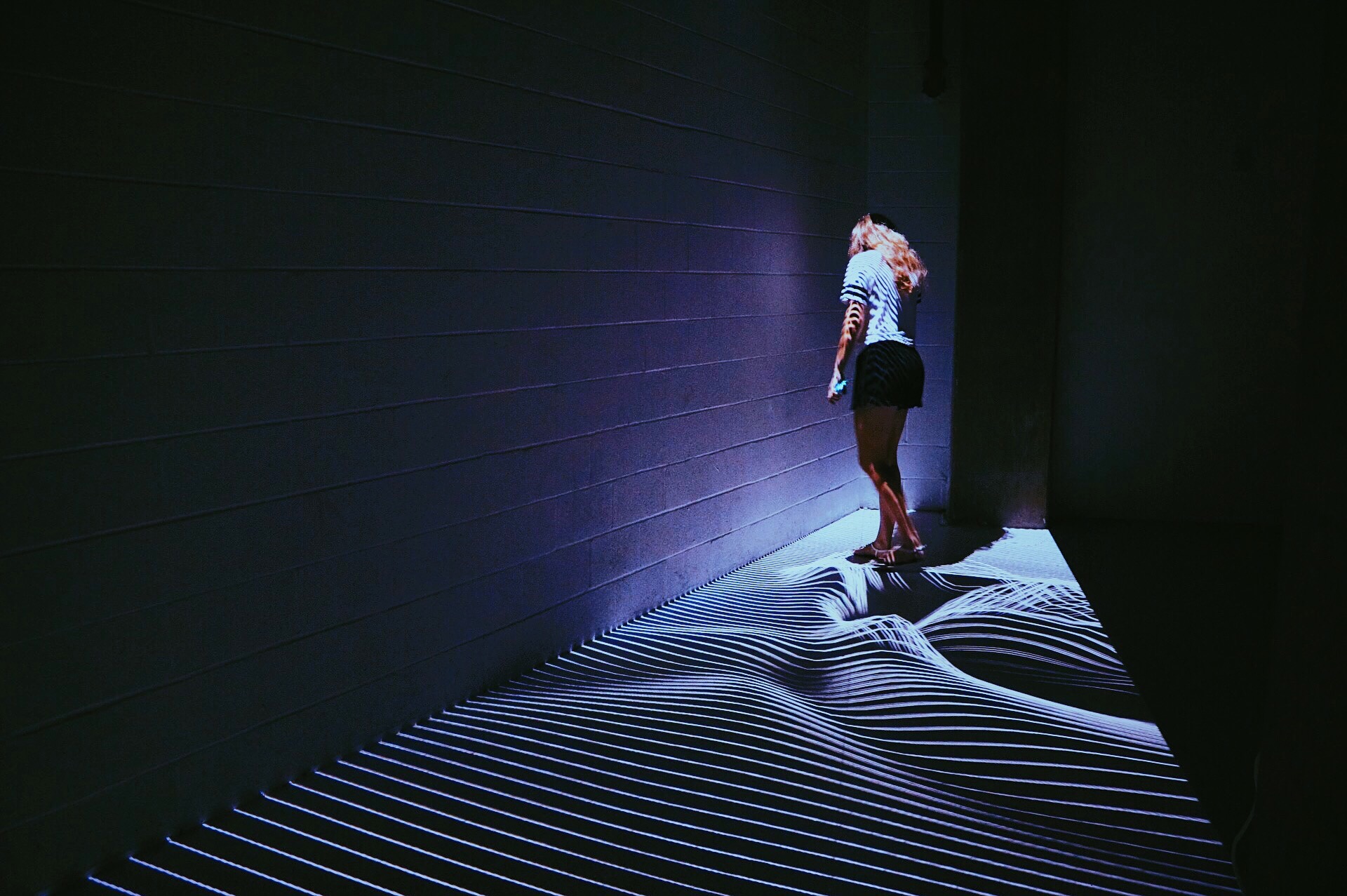 person walking on stripes of light