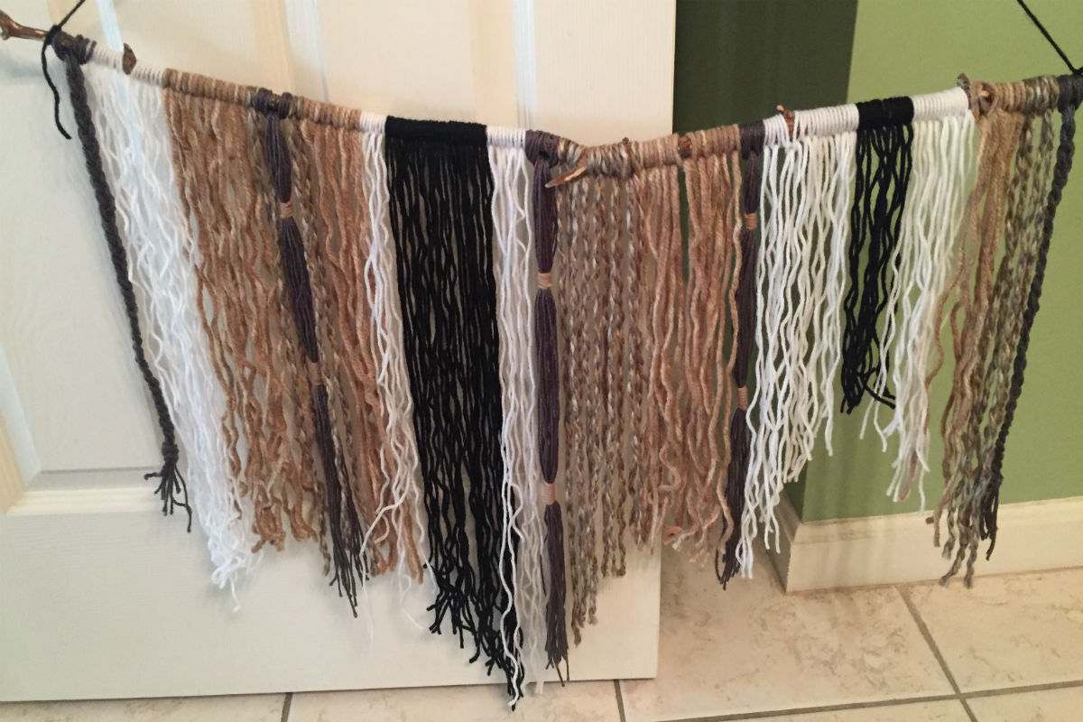 natural colored yarn hanging from a stick