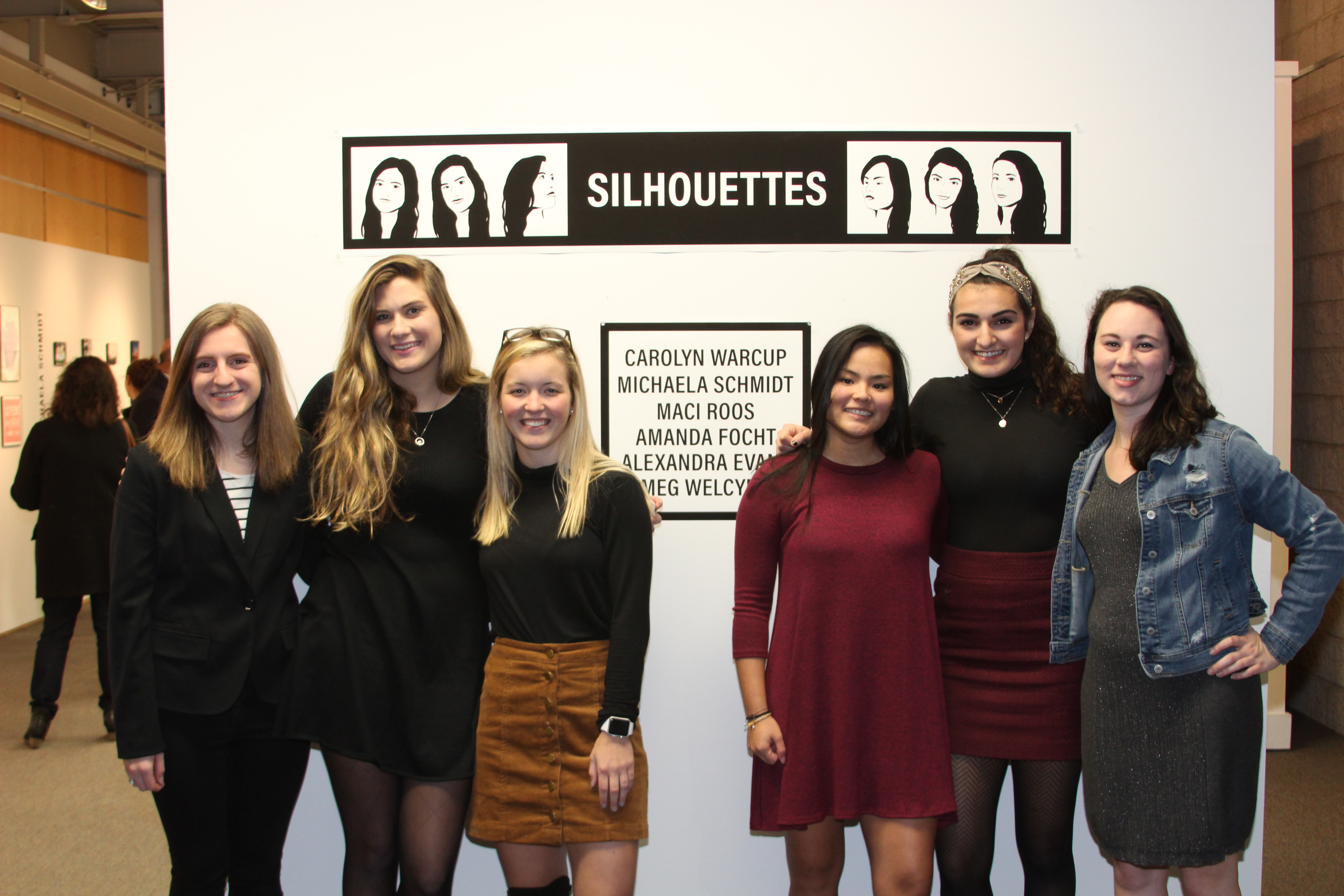 girls standing in front of posters