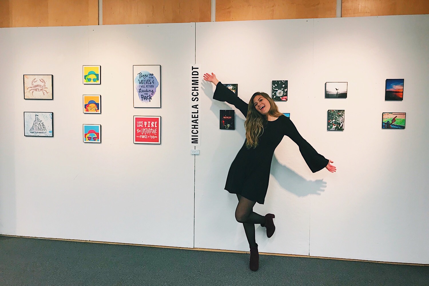 girl standing in front of pieces of art