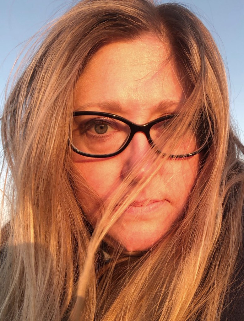 Woman with green eyes and light skin and dirty blond hair