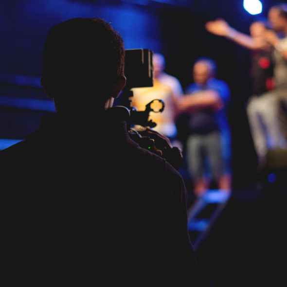 man standing on stage holding microphone