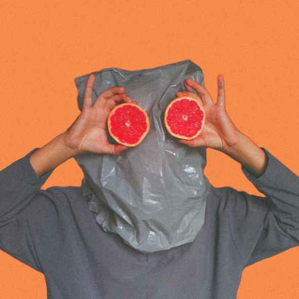 person covered with plastic bag on head while holding sliced blood orange
