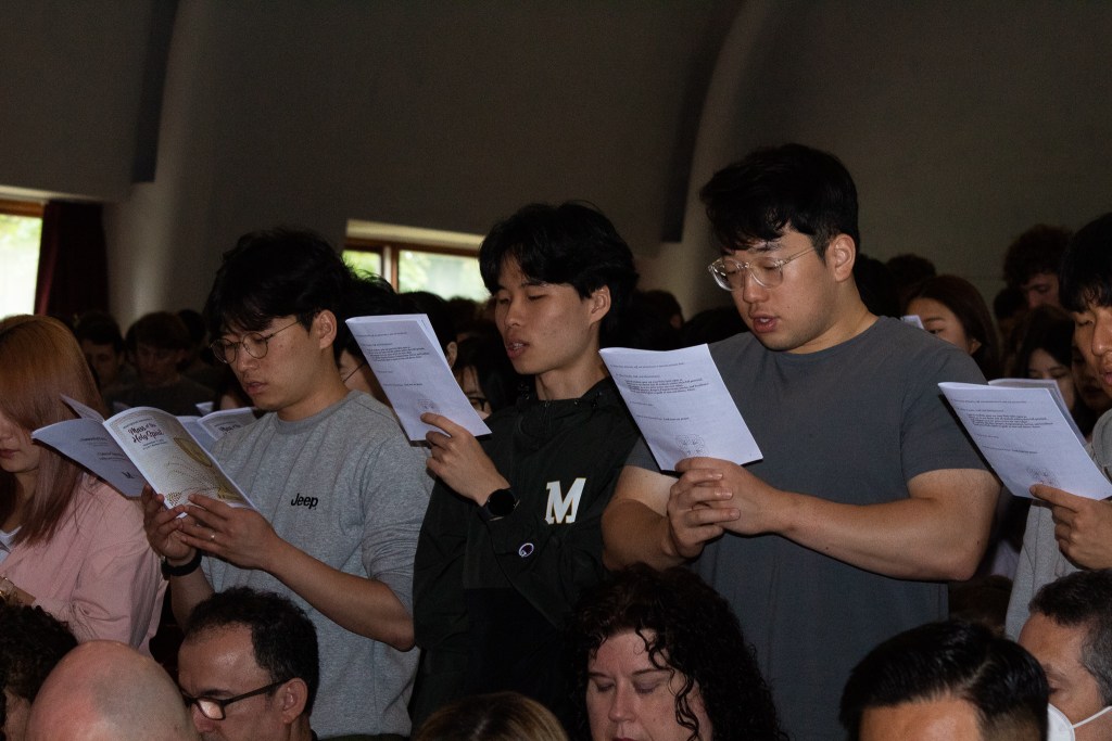 Students standing, reading from a pamphlet