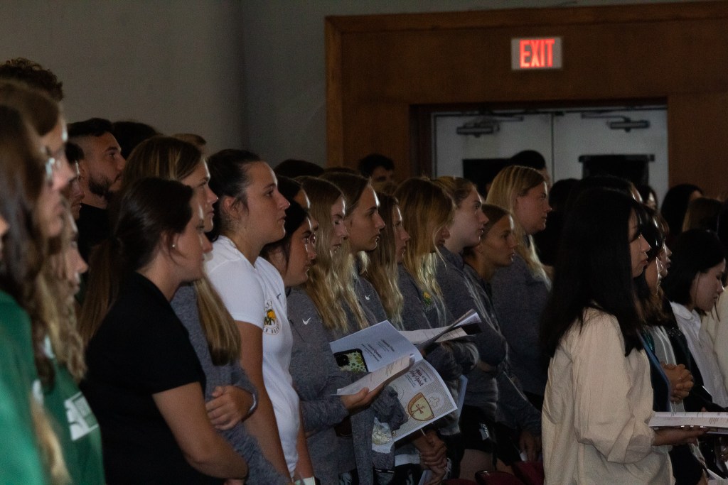 Students standing, reading from a pamphlet