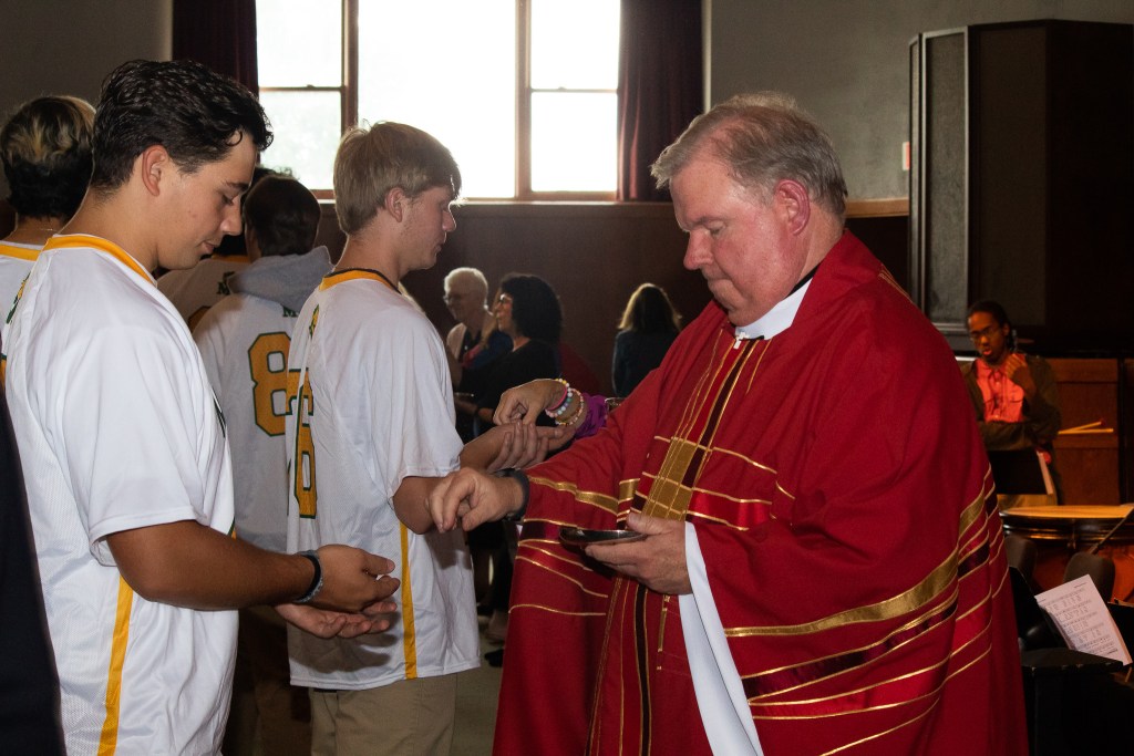 Man putting water into students hands