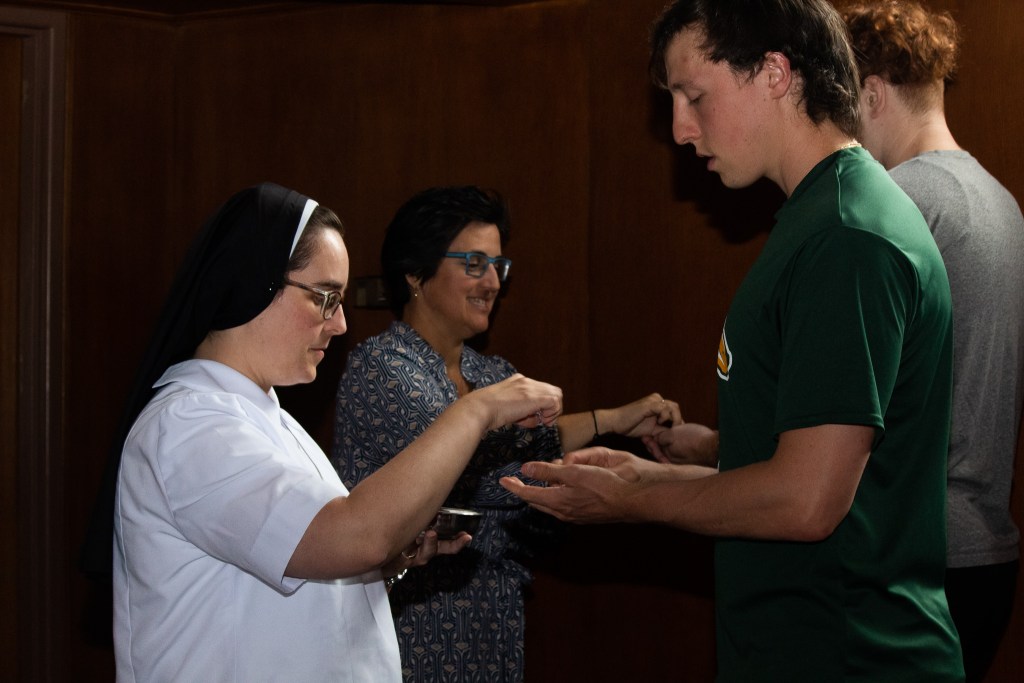 Woman putting water into students hands