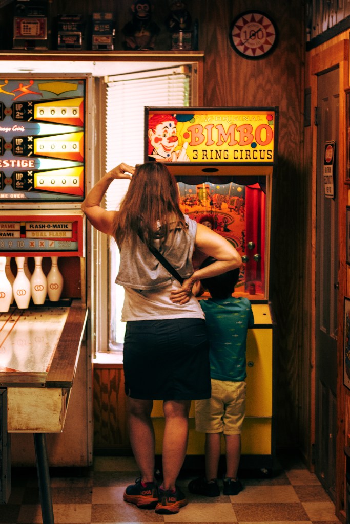 A mother and a son playing an arcade game