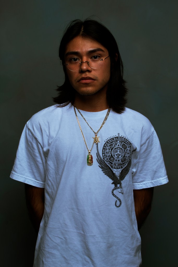 Person in a white t-shirt standing in front of a grey background
