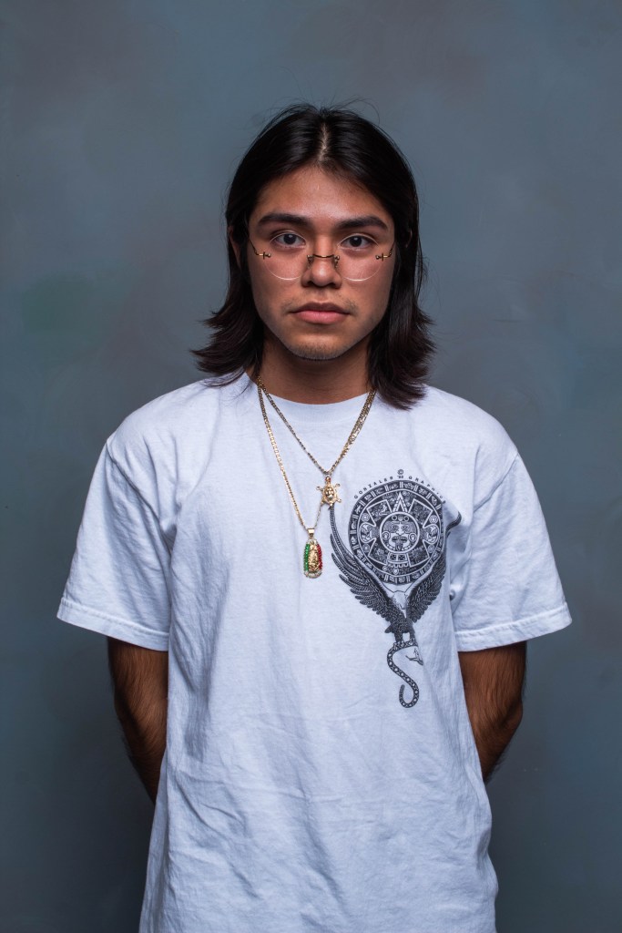 Portrait of a person in a white t shirt in front of a grey background