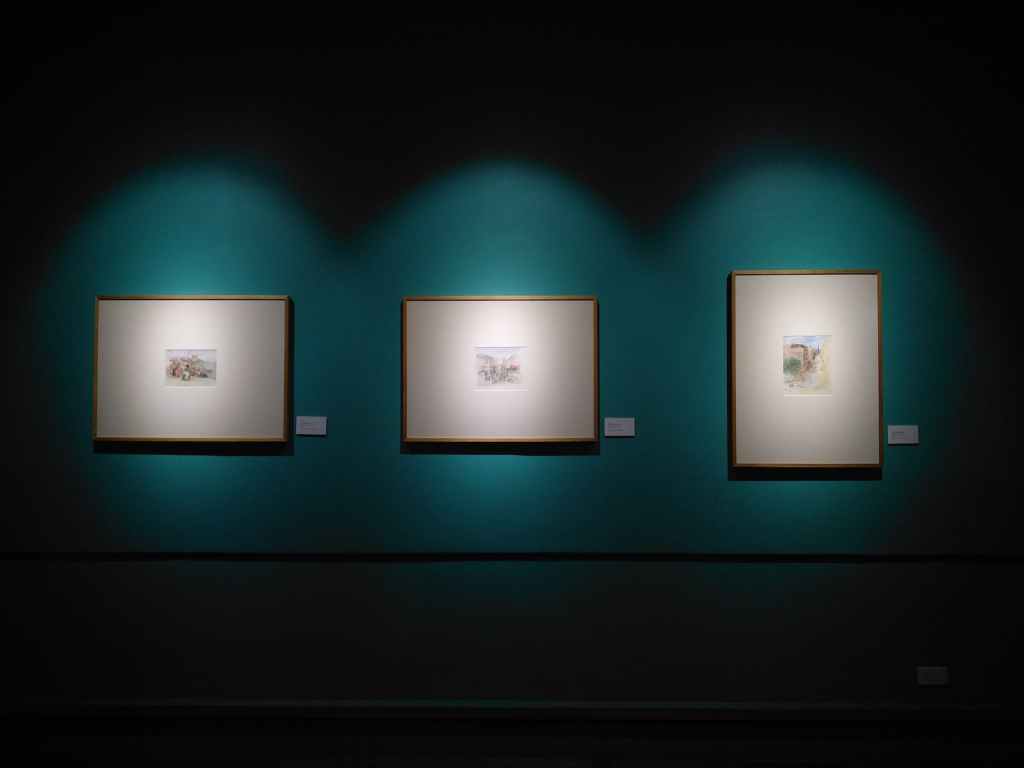 three paintings hanging in gallery