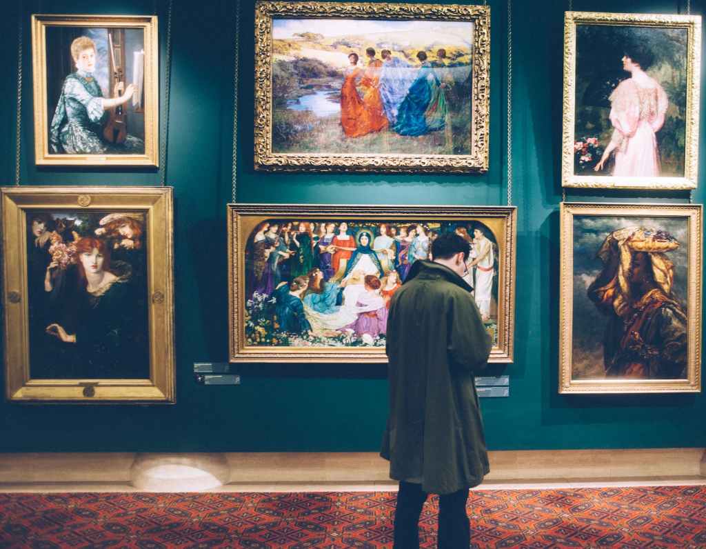 man standing in front of paintings