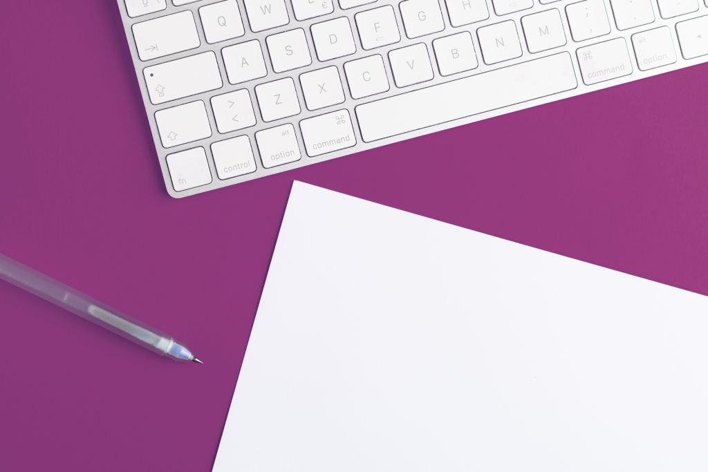 Image of keyboard, pen, and paper.